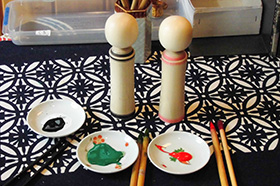 Painting Nakuko Kokeshi Dolls.